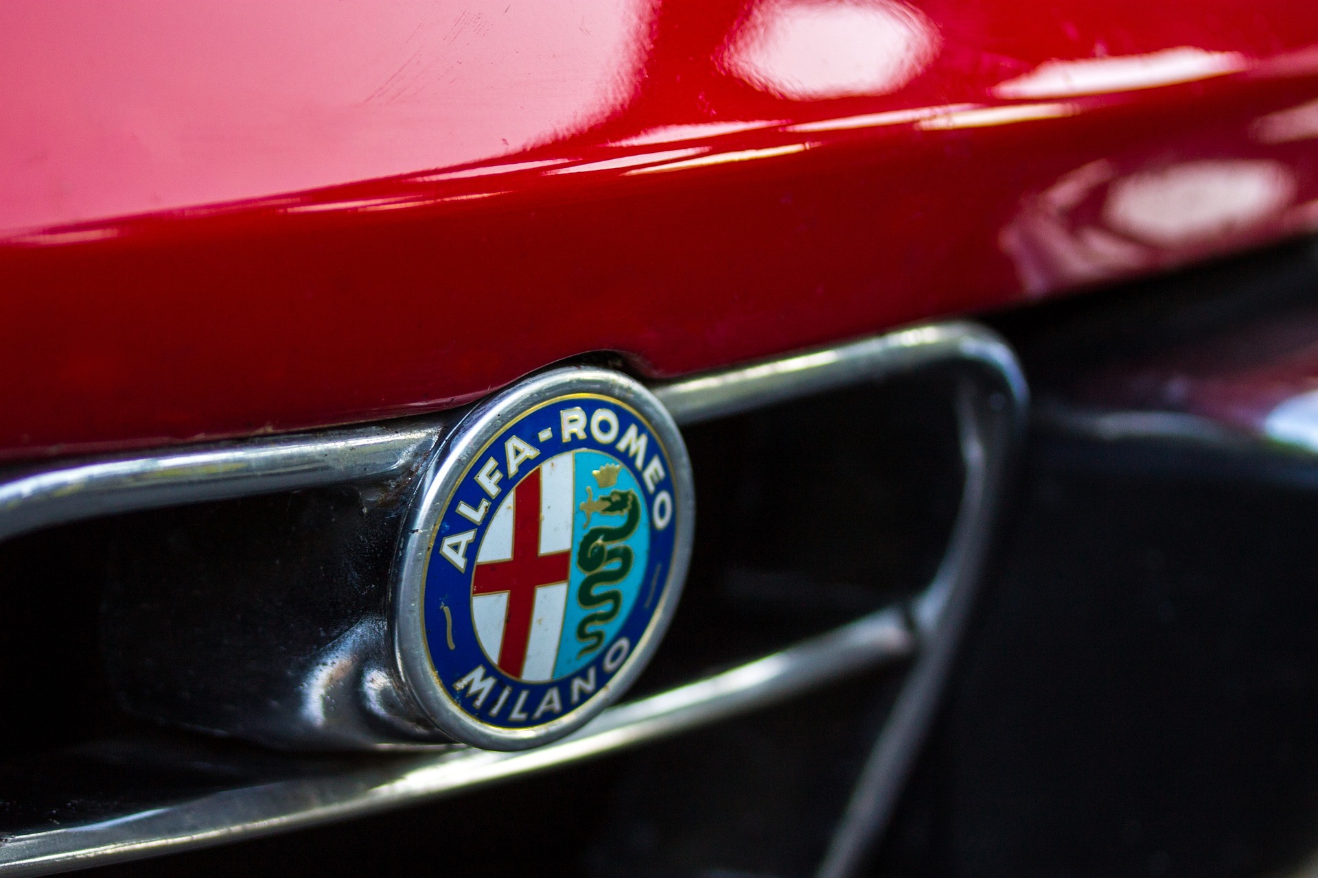 A closeup shot of the Alfa Romeo crest on the front of a grill